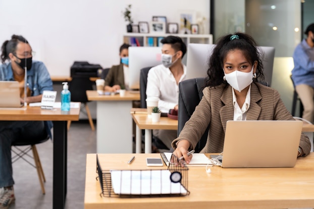  Portrait office employees wearing face mask while social distancing