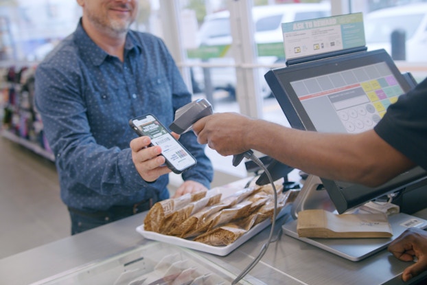man scanning his phone app at 7-eleven