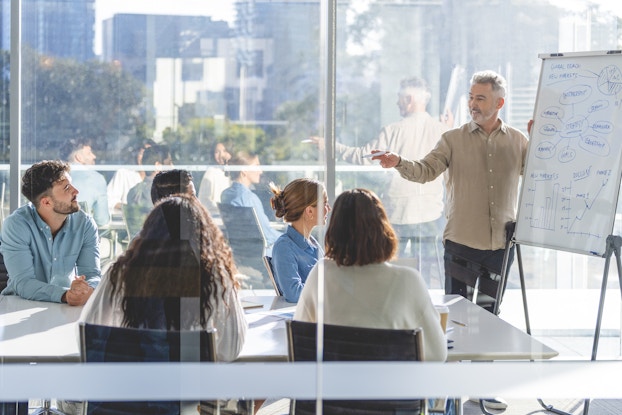  Business people watching a presentation on the whiteboard.