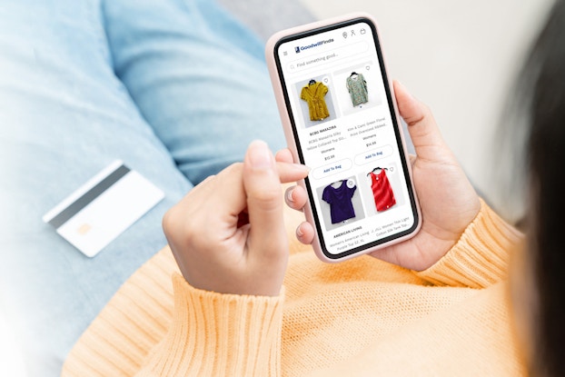  Person shopping on GoodwillFinds.com on their phone.