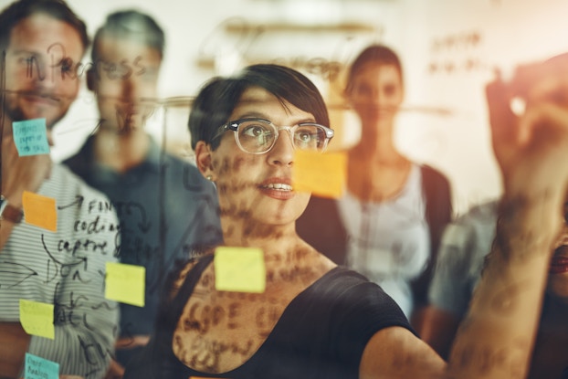  A group of young designers using sticky notes during a brainstorming session