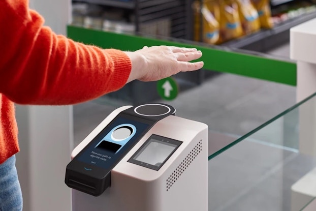  Amazon One biometric technology scanning a person's hand at a Whole Foods location.