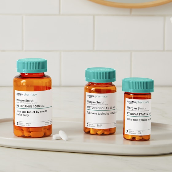 Display of prescription bottles and pills filled by Amazon Pharmacy.