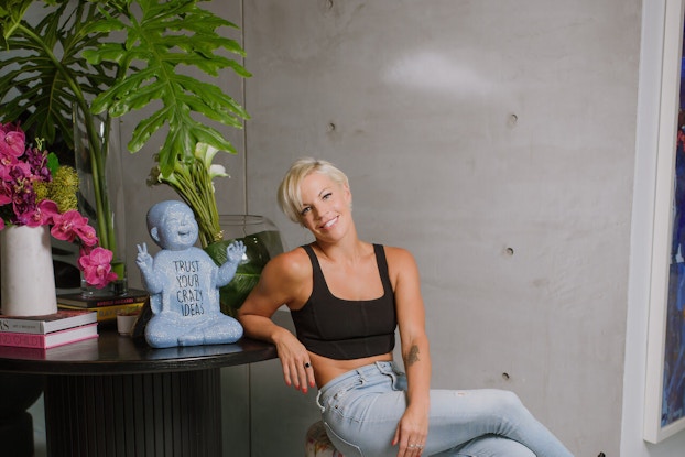 Anne Mahlum, the Founder and former CEO of Solidcore is shown seated at a table smiling at the viewer.