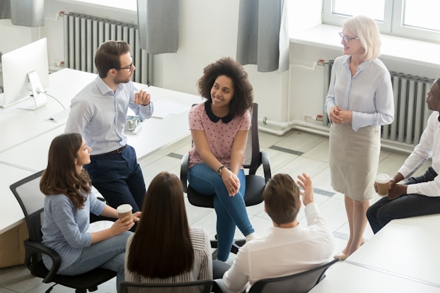 Employee group actively in discussion at office meeting.