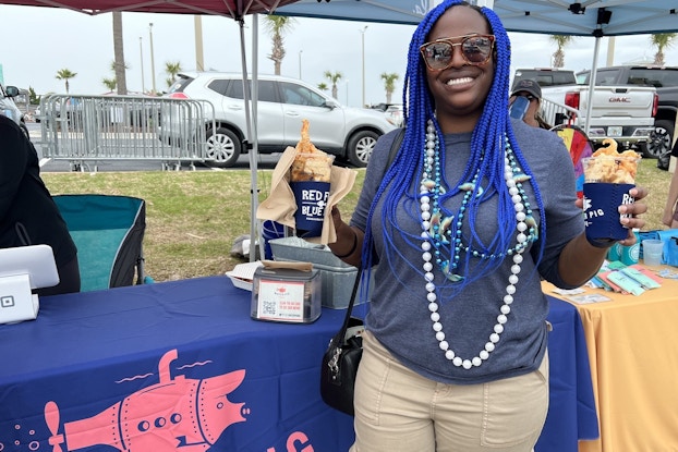  Customer wearing Mardi Gras beads and holding the BBQ Sundae from Water Pig BBQ.