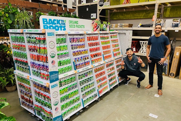  Co-founders of Back to the Roots standing with a product display inside a store.