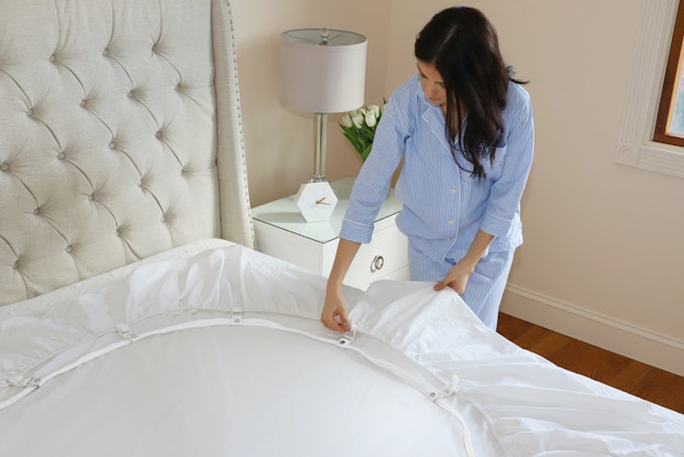  Woman making her bed using the Bed Scrunchie.