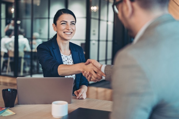  Businesswoman smiles as she makes a deal.