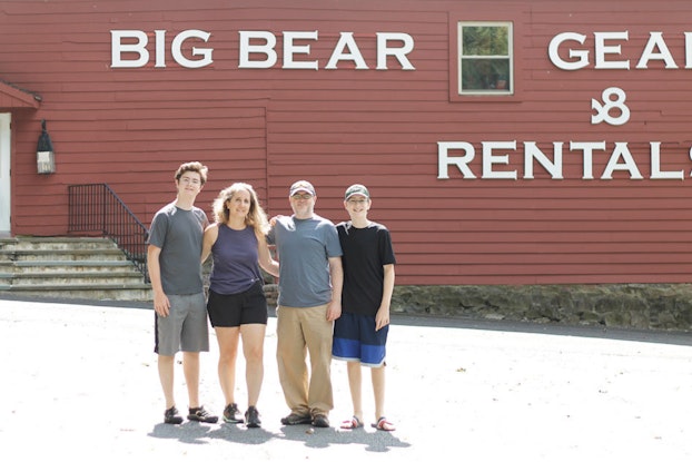 Group of people stand outside a outdoor equipment storefront