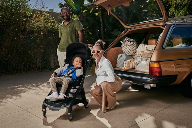 Mother and father packing their car with their child in a Bugaboo Butterfly stroller.