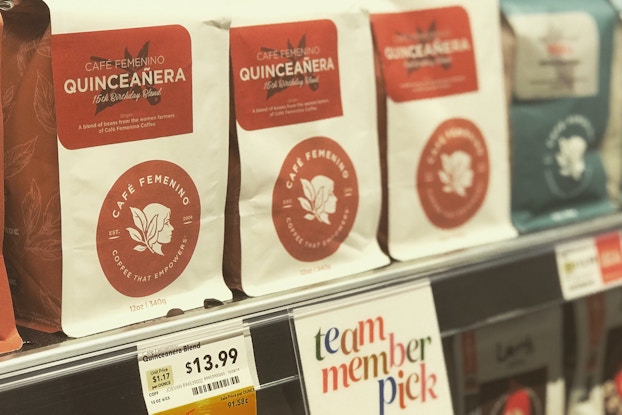 Bags of coffee by Cafe Femenino on a grocery store shelf.
