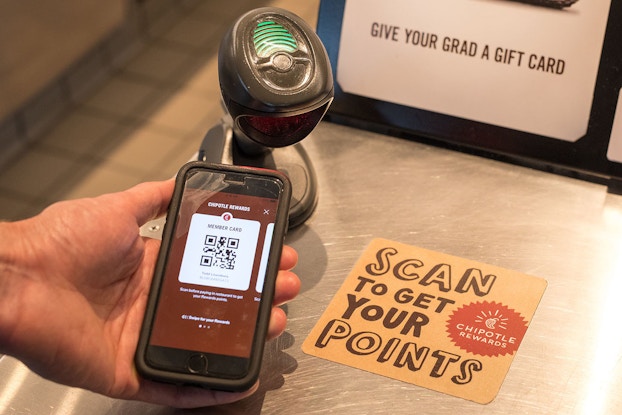  Person using barcode on phone to scan for Chipotle Rewards program.