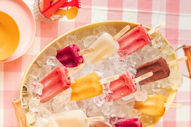  A bowl of Chloe's frozen fruit pops on a checkered tablecloth.
