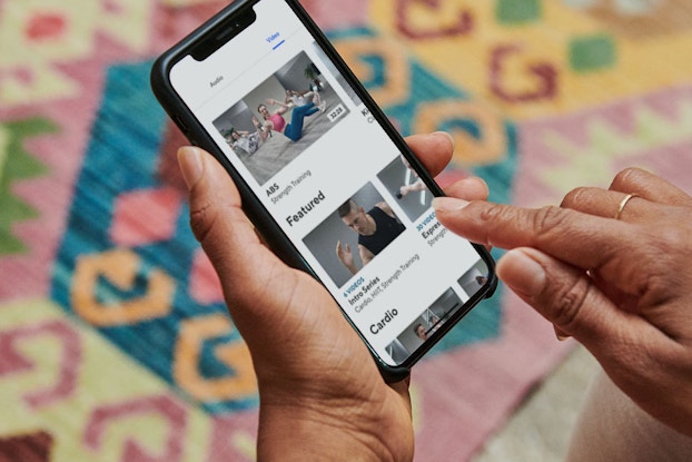 person holding phone browsing classpass workouts