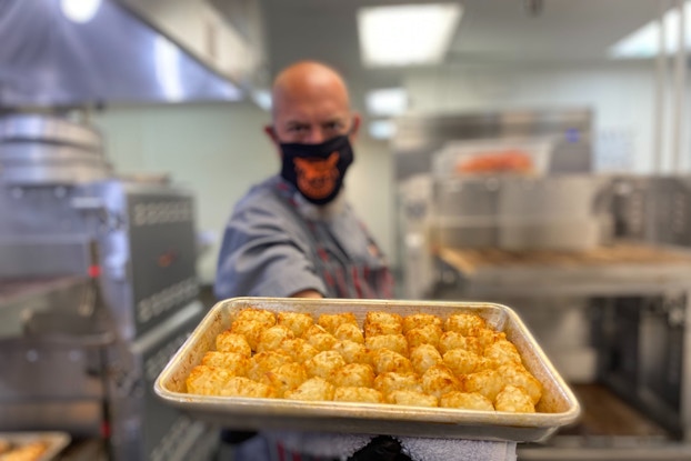  Employee preparing food inside of delivery-only restaurant Cluster Truck.