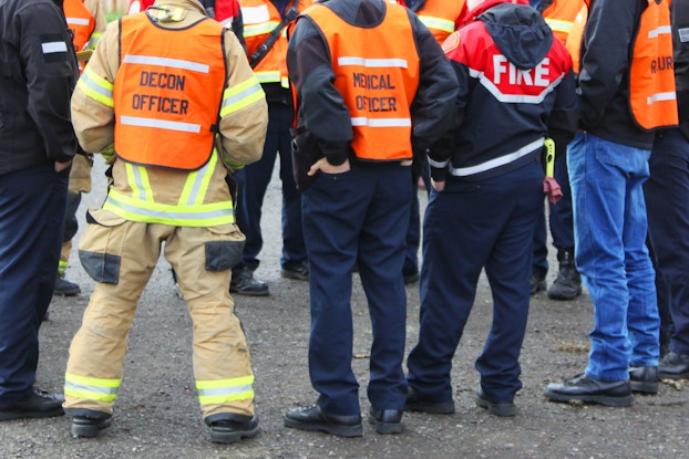 Emergency response team stands in a circle to discuss a plan.