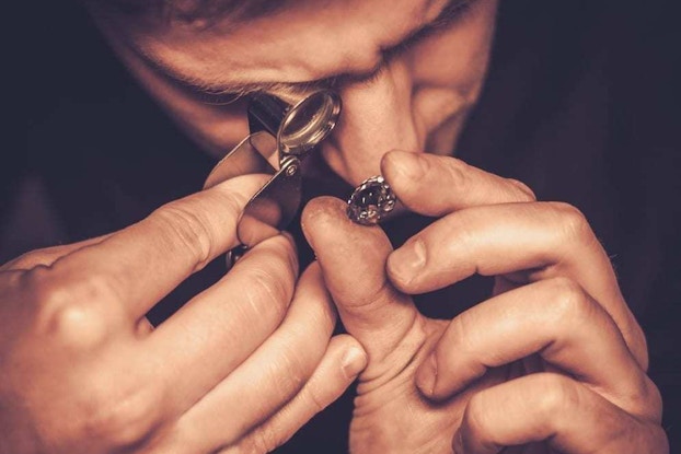 Man looking at diamond through loop