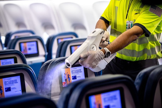 worker on delta plane using sanitizer machine