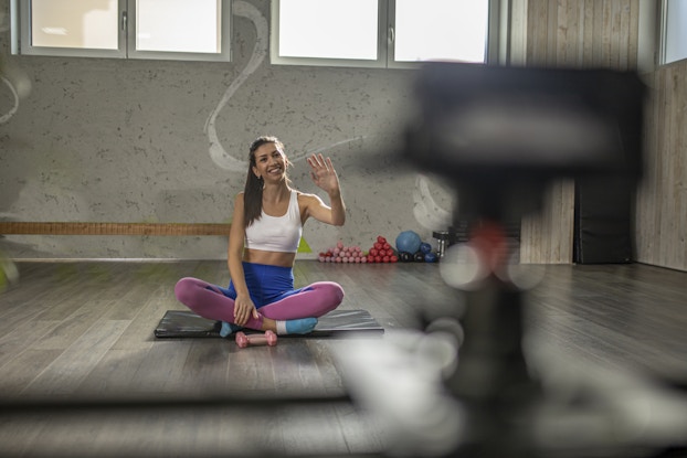  Woman greets virtual fitness class participants