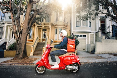  DoorDash employee delivering a last-mile parcel on a scooter. 