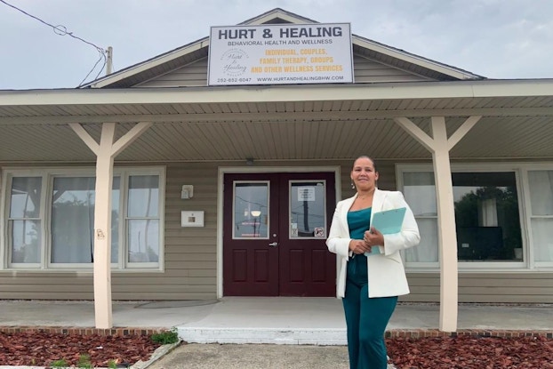  Dr. Che Hurt standing in front of her practice, Hurt & Healing Behavioral Health & Wellness.