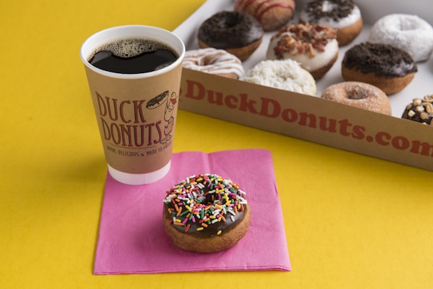 Duck Donuts' coffee and donuts on a table.