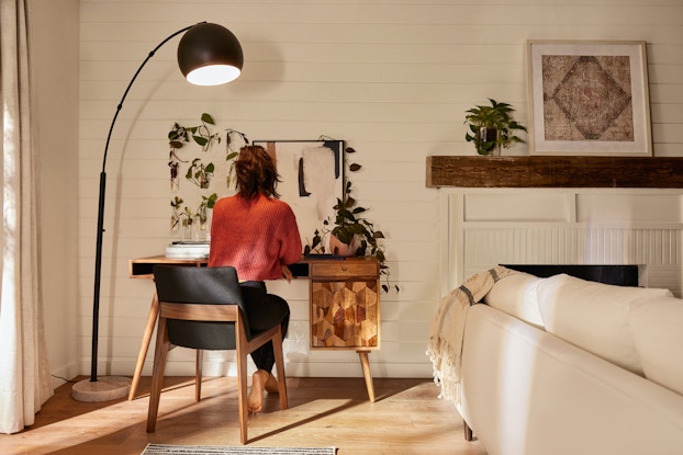 Woman working in her home office, an image provided by Fernish with rental office furniture.