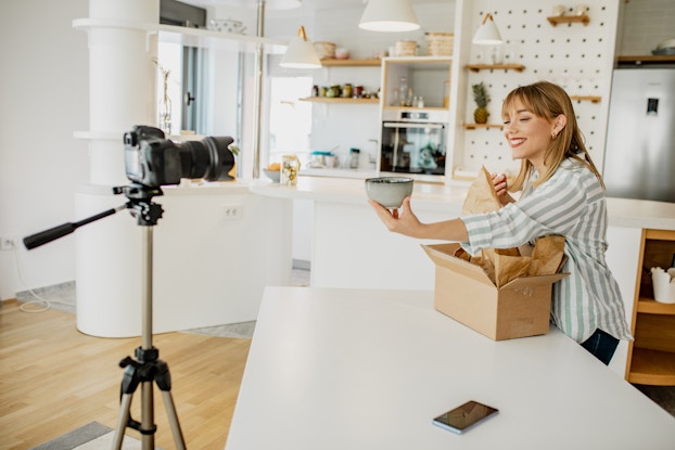  Pottery artist creates a video of her packing a product in a clean, brightly lit room.