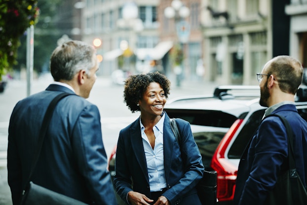  Woman talking to business colleagues outside