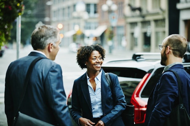 Woman talking to business colleagues outside