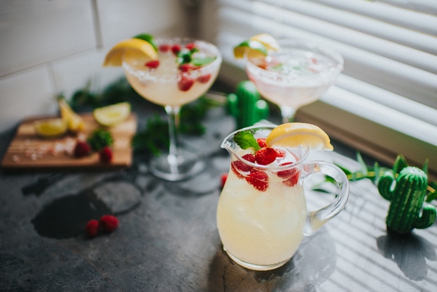  Three cocktails or mocktails pictured on a countertop.