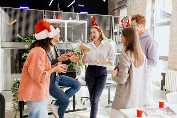  Team of coworkers wearing holiday hats at work.