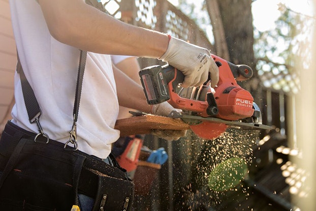  A Thumbtack handyman working on a construction project, sawing wood.
