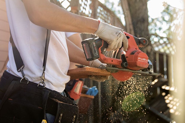 A Thumbtack handyman working on a construction project, sawing wood.