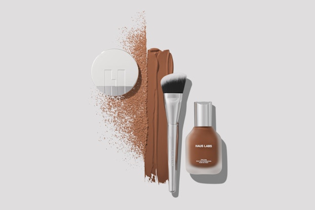 Foundation bottle and powder compact and makeup brush by Haus Labs by Lady Gaga.