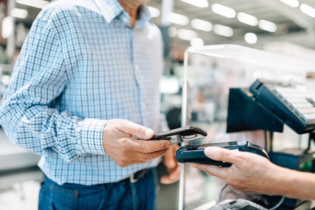  Customer pays for a purchase using contactless payment at a POS.