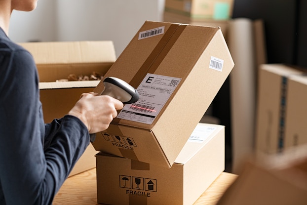 Employee scans the barcode on a package in the shipping process.