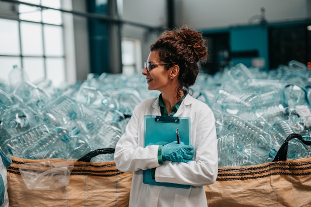  Young happy female worker in bottling factory recycling department.