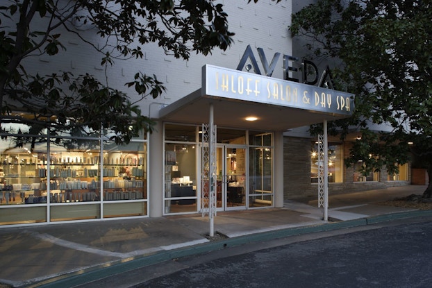 Products in the window of a storefront are illuminated at dusk.