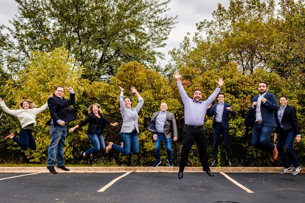  Business people pose happily in a parking lot