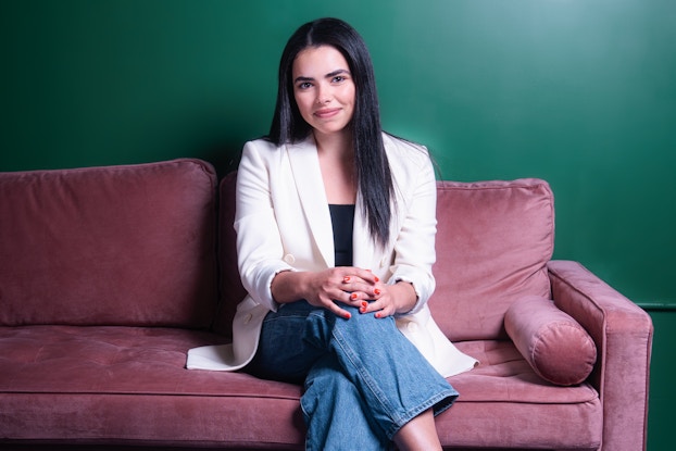  Shot of Katie Diasti, founder of Viv, sitting on a pink couch.