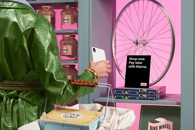 person shopping in store looking at sign for klarna's payment options
