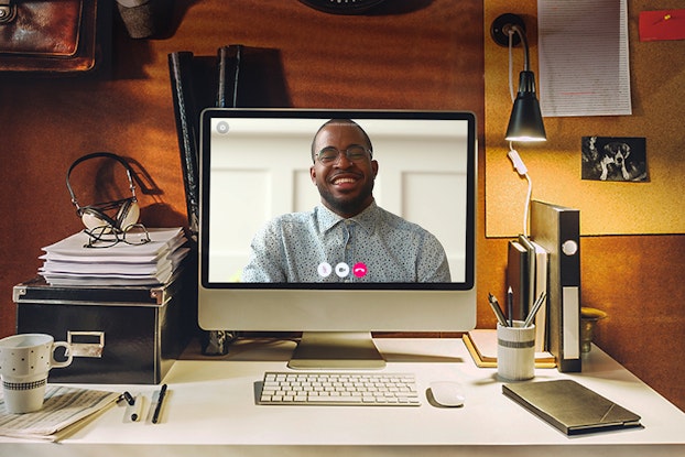 A person's face on a computer screen during a video call.