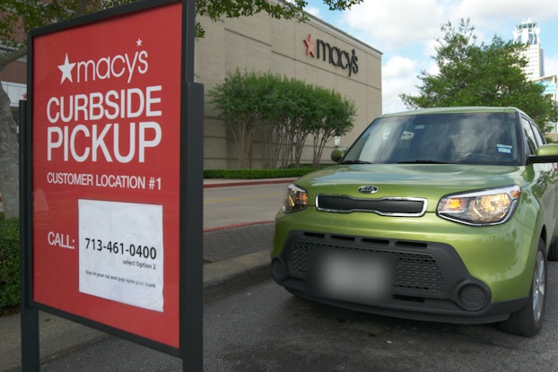 macy's curbside pickup sign with car parked