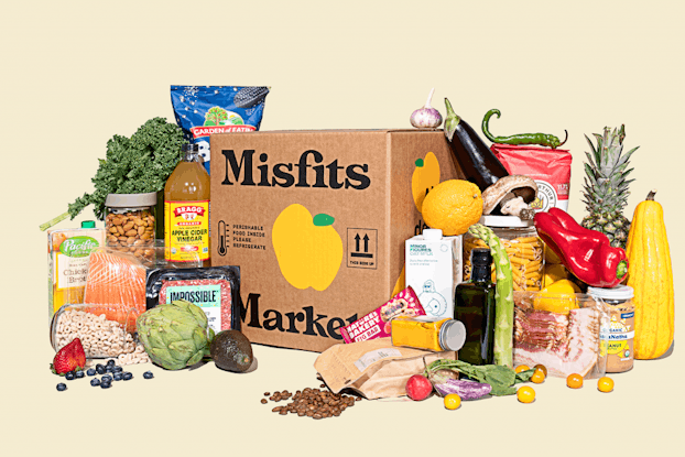 Misfits Market delivery box surrounded by produce and other food items the company sells.