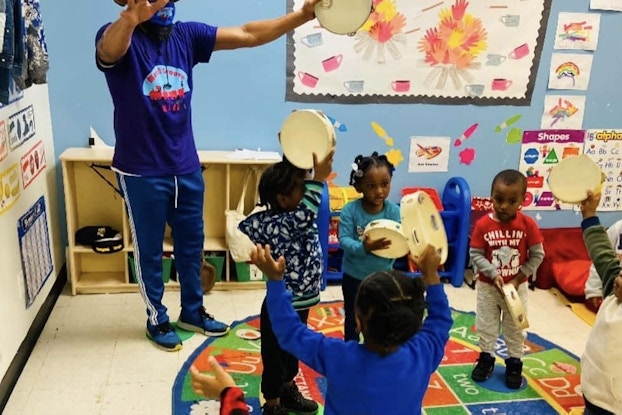 Move N Groove Kidz employee in a classroom working with young children.