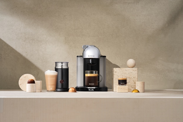Nespresso machine on a countertop brewing coffee.