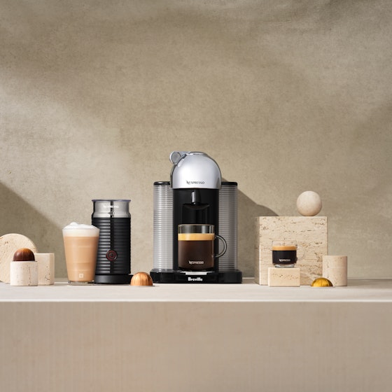 Nespresso machine on a countertop brewing coffee.