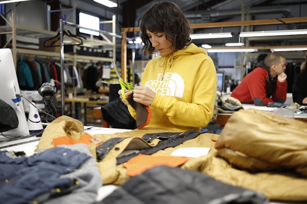  the north face employee working on clothing for renewed initiative